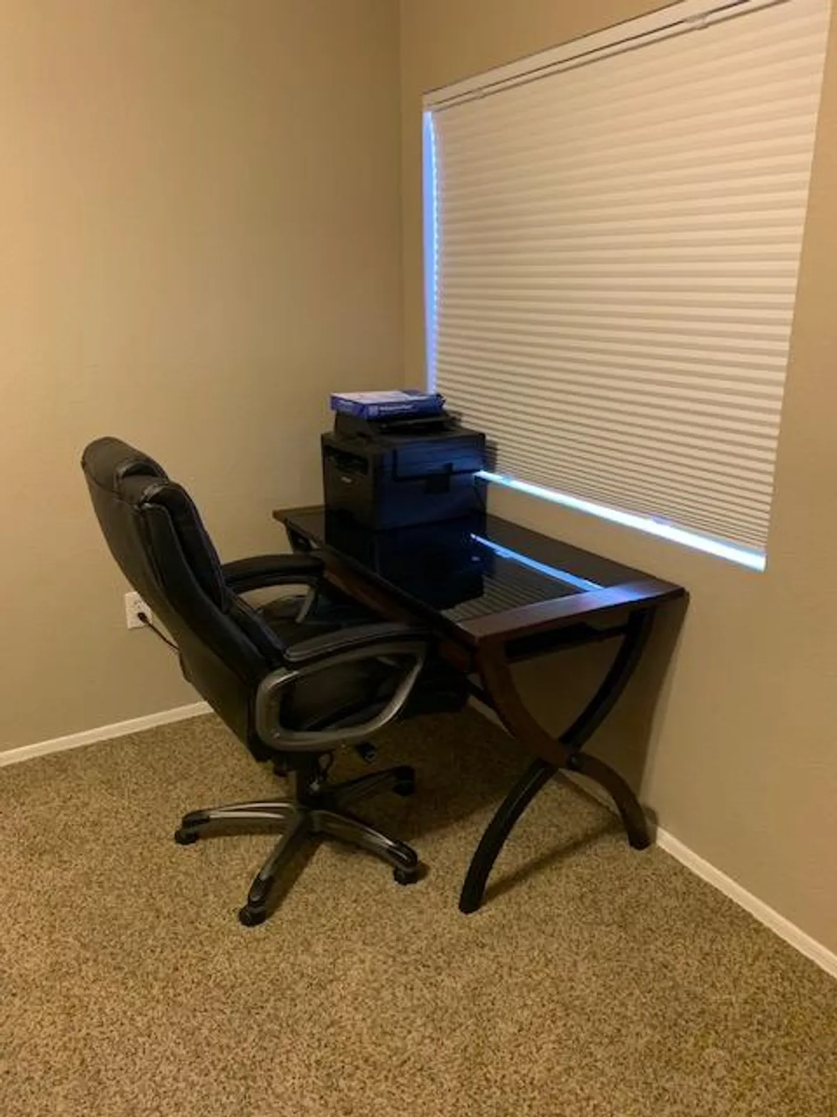 A stylish workspace featuring a modern desk, ergonomic office chair, and a window that brings in abundant natural light. The scene is uncluttered, with calming tones that invite productivity and focus. The window subtly hints at the world outside, reinforcing the connection between a private, peaceful home base and the surrounding city.